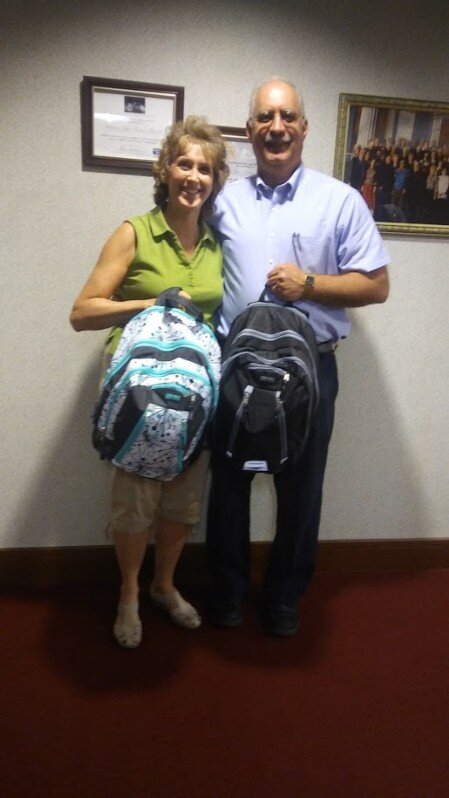 Benefactors delivering backpacks